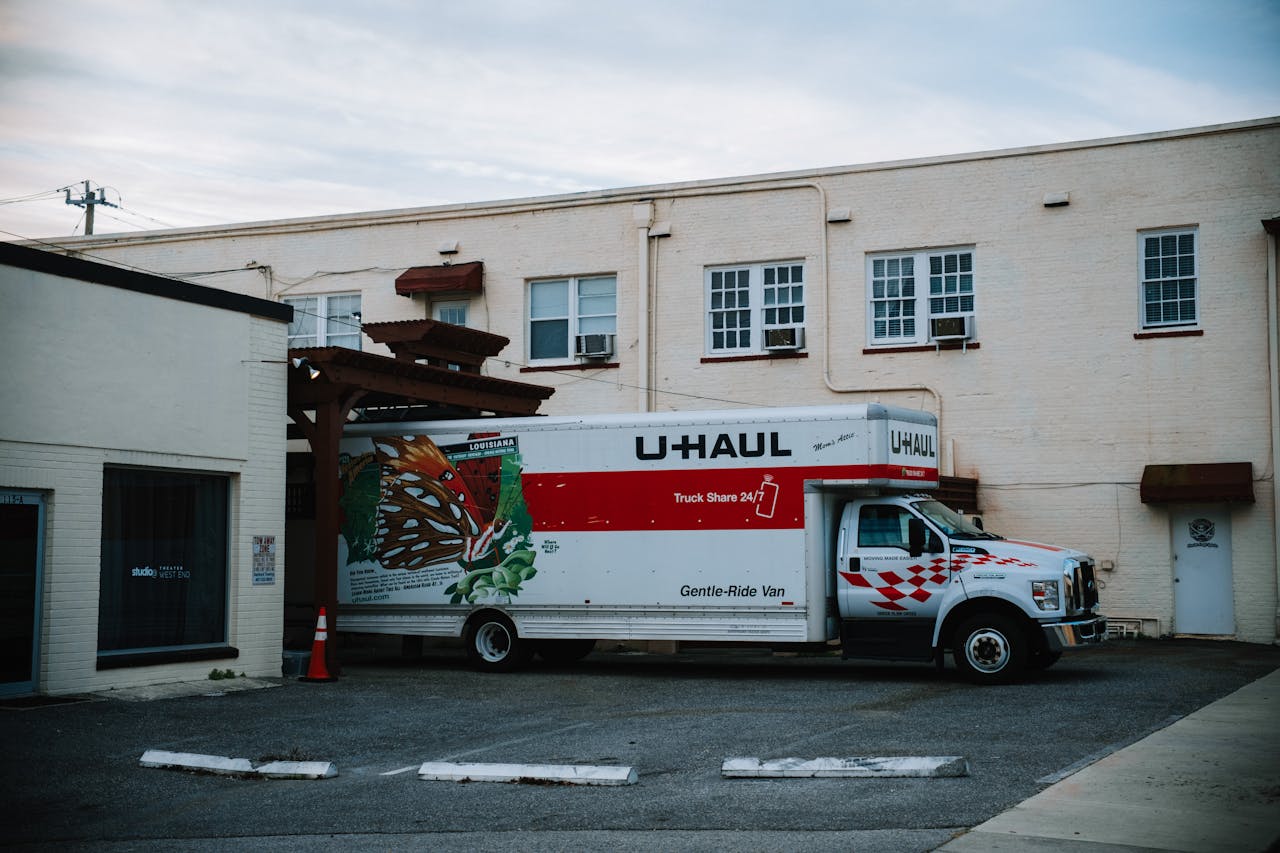 portfolio-01 A U-Haul moving truck parked in front of a beige warehouse building.